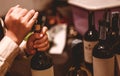 The bartender opens a bottle of red wine using a wine opener. To pour a lot of empty glasses at the bar counter. Blurred backgroun Royalty Free Stock Photo