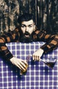 Bartender overdrink, drunk. Man in checkered shirt on wooden background, blue tablecloth. Royalty Free Stock Photo
