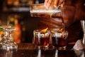 Bartender pouring alcoholic drink into the glasses Royalty Free Stock Photo