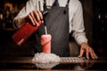 Bartender pouring alcoholic sparkling water into a glass with sweet red berry summer cocktail with foam Royalty Free Stock Photo