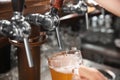 Bartender pouring beer from tap into glass, closeup Royalty Free Stock Photo