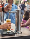 Bartender pouring bright beer from the crane.