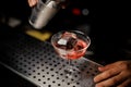 Bartender pouring campari liquor from shaker into the cocktail glass Royalty Free Stock Photo