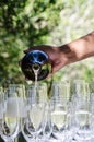 Bartender pouring champagne into wine glasses at outdoors celebration