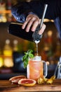 Bartender pouring drink making a Lynchburg lemonade - fresh tennessee whiskey cocktail