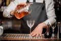 Bartender pouring fresh alcoholic drink into the cocktail glass Royalty Free Stock Photo