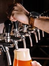 Bartender pouring fresh beer into glass in pub Royalty Free Stock Photo