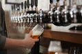 Bartender pouring fresh beer into glass in pub Royalty Free Stock Photo