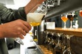 Bartender pouring fresh beer into glass in pub Royalty Free Stock Photo