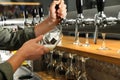 Bartender pouring fresh beer into glass in pub Royalty Free Stock Photo