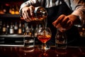 A bartender pouring a perfectly measured shot of liquor into a mixing glass, demonstrating precision and expertise in cocktail