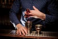 Bartender pouring a portion of pink alcohol drink into the shaker