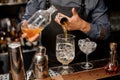 Bartender pouring a portion of syrup into the large cocktail glass Royalty Free Stock Photo