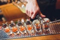 Bartender pouring strong alcoholic drink into small glasses on bar, shots. Royalty Free Stock Photo