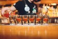 Bartender pouring strong alcoholic drink into small glasses on bar, shots. Royalty Free Stock Photo