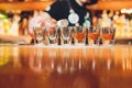 Bartender pouring strong alcoholic drink into small glasses on bar, shots. Royalty Free Stock Photo