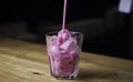 Bartender pouring a strong alcoholic drink into small glasses with ice. Red alcoholic drink. Barman is preparing a cocktail Royalty Free Stock Photo