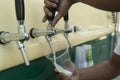 Bartender pouring from tap fresh beer into the plastic cup Royalty Free Stock Photo