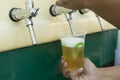 Bartender pouring from tap fresh beer into the plastic cup Royalty Free Stock Photo