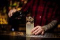 Bartender pourring a achohol from the bottle making a delicious