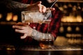 Bartender pourring an alcohol making a hard James Cook cocktail