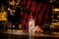 Bartender pourring an alcohol making a Tom Collins cocktail