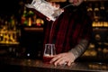 Bartender pourring a Sazerac cocktail from the measuring cup wit