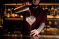 Bartender pourring a Sicilian Tonic achoholic drink from the cocktail steel shaker