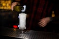 Bartender pourring a white achoholic drink from the bottle