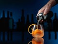 The bartender pours a cocktail from a shaker into a glass with ice Royalty Free Stock Photo