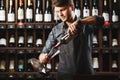 Bartender pours red wine in transparent vessel in cellar Royalty Free Stock Photo