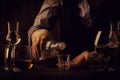 The bartender pours the vodka or tequila in small shot glass on the old bar counter. Vintage wooden background in pub or bar, Royalty Free Stock Photo