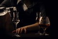 The bartender pours the vodka or tequila in small shot glass on the old bar counter. Vintage wooden background in pub or bar, Royalty Free Stock Photo