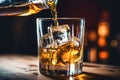 The bartender pours whiskey into a glass with ice on the bar counter. close-up. Blurred background. Elite alcoholic drink Royalty Free Stock Photo