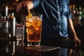 A bartender prepares a cocktail, adding a lemon twist in a dimly lit bar