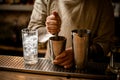 Bartender prepares cocktail in shaker cup using the muddler