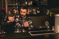 Bartender preparing cocktail behind bar counter, pouring berry liquor into glass Royalty Free Stock Photo