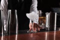 Bartender preparing fresh alcoholic cocktail in martini glass at bar counter, closeup Royalty Free Stock Photo