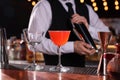 Bartender preparing fresh alcoholic cocktail and martini glass on bar counter, closeup Royalty Free Stock Photo