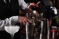 Bartender preparing fresh alcoholic cocktail in martini glass at bar counter, closeup Royalty Free Stock Photo