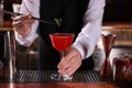 Bartender preparing fresh Martini cocktail in glass at bar counter, closeup Royalty Free Stock Photo