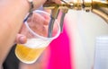 A bartender serving beer at a dispenser in plastic glasses Royalty Free Stock Photo