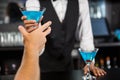 Bartender serving blue cocktail at bar counter Royalty Free Stock Photo