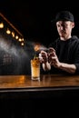 Bartender spraying and fire whiskey in alcoholic cocktail at bar. Bartender is preparing alcoholic cocktail with whiskey