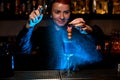 Bartender spraying olives and flower on toothpick