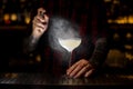 Bartender sprinkling elegant cocktail glass with alcoholic drink with bitter in dark Royalty Free Stock Photo