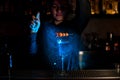 Bartender sprinkling olives and flower on toothpick