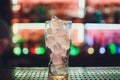 Bartender squeezing juice from fresh lime in a glass using citrus press and splashing it out making an alcoholic Royalty Free Stock Photo