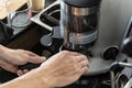 Bartender using coffee grinder. Male getting ready to make fresh espresso in coffee maker.