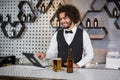 Bartender using digital tablet at bar counter